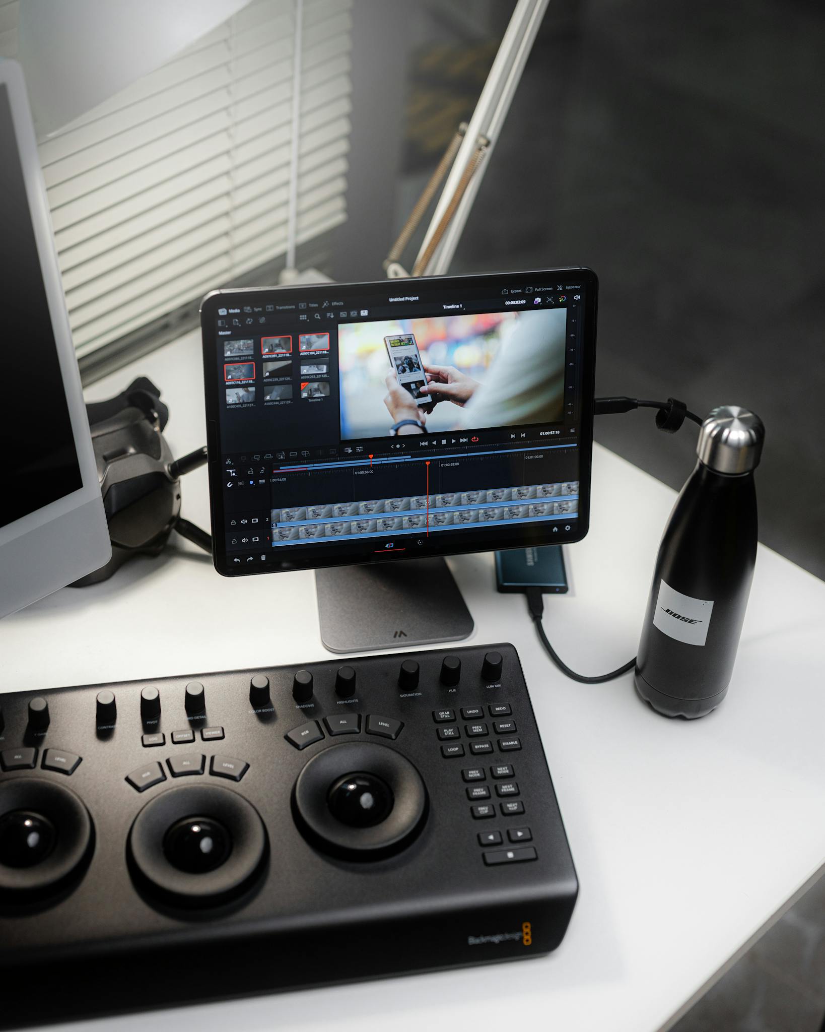 A sleek video editing workspace featuring a tablet, control panel, and monitor, highlighting technology in media production.